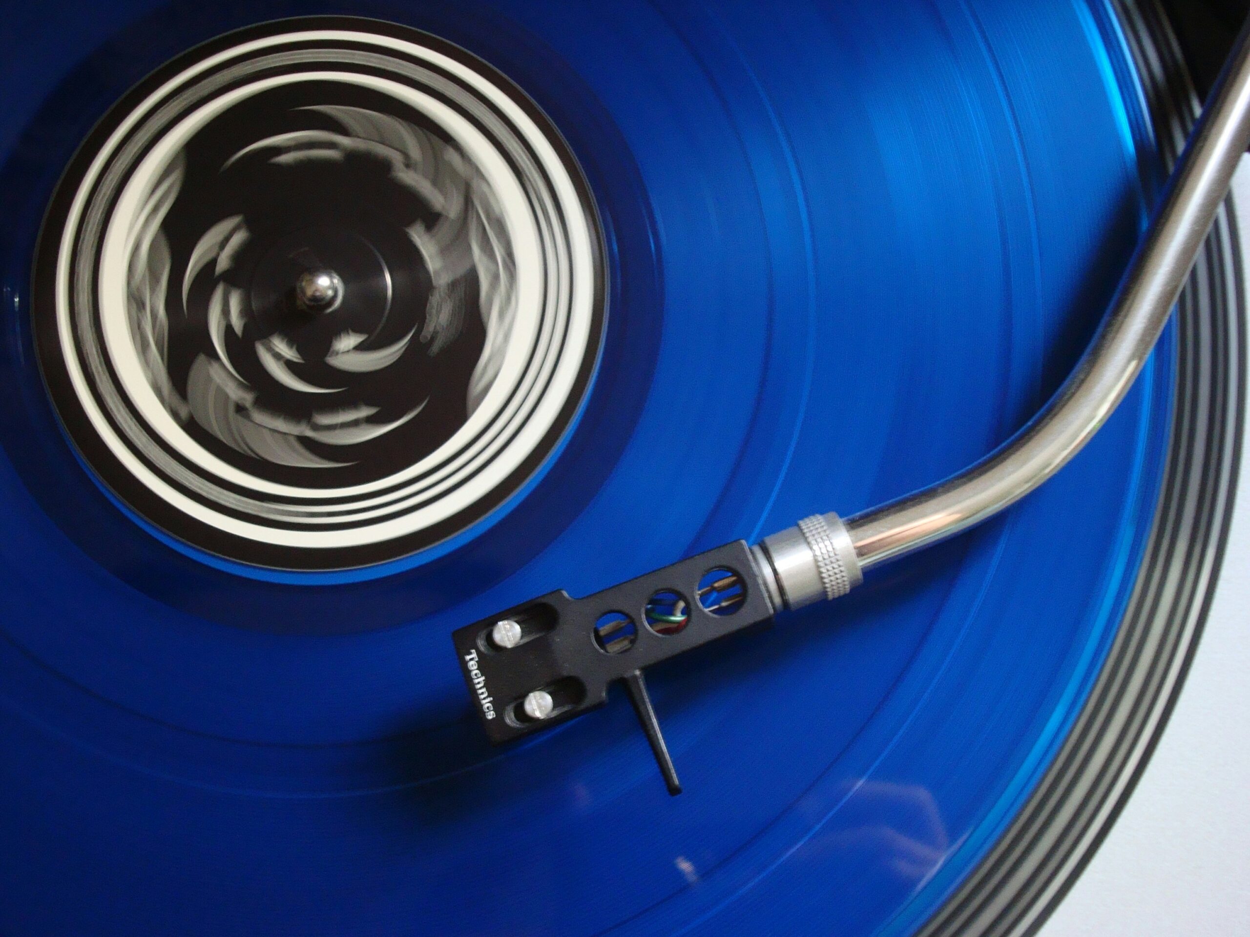 image of a turntable with a needle on a blue vinyl record