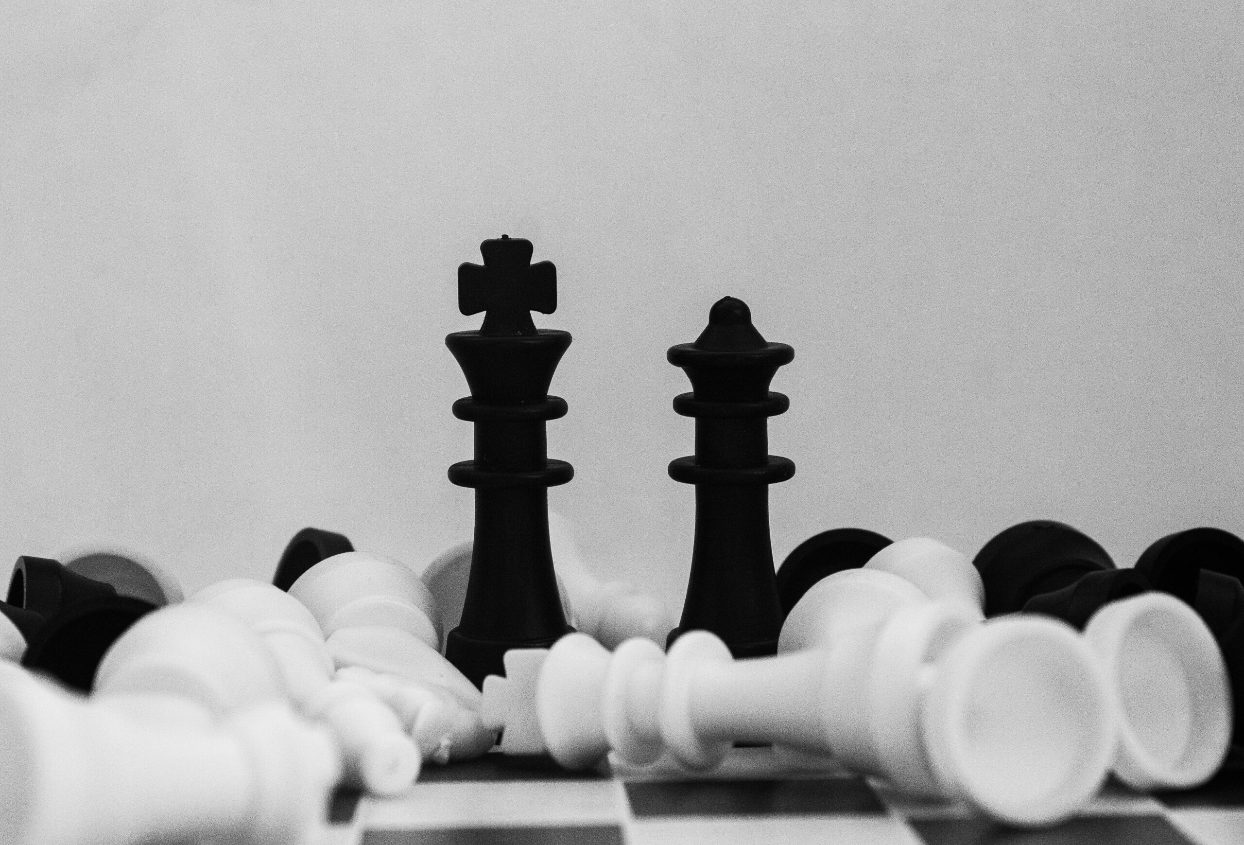 image of black and white chess pieces scattered on a chess board